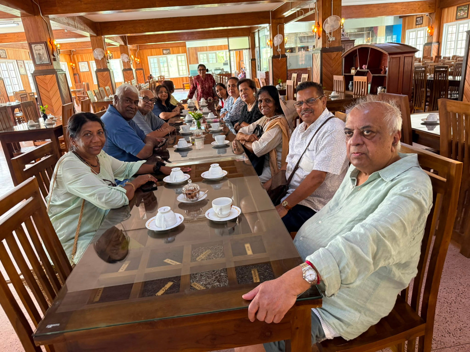 Mauritius Social Group members seated together around a long table at a tea room in India